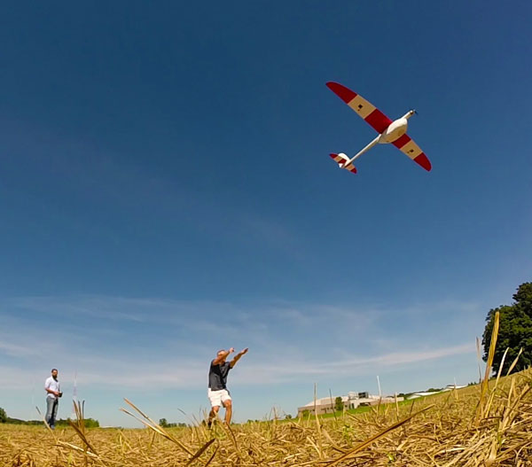 Image of person launching a fixed wing drone from a field
