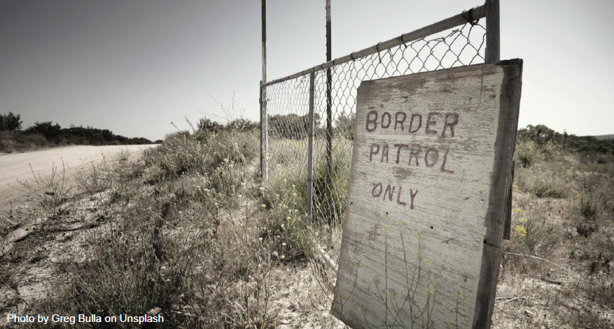 Image of hand-painted sign leaning again fence reading "Border Patrol Only." Photo by Greg Bulla on Unsplash