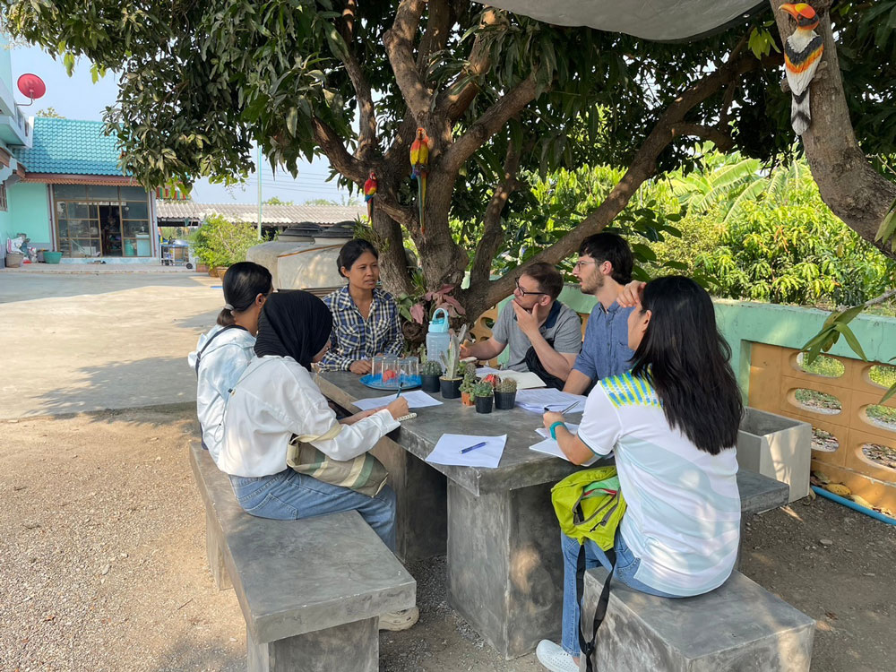 The team (Leo, Ben, and Orachos) interviews a fish farmer at their home in Suphanburi Province. 