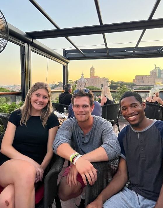 Hannah Fulmer, Henry Shaban, and Carlton Mamo at the Hotel Forum Roma roof garden terrace enjoying the panoramic view of the Roman Forum.